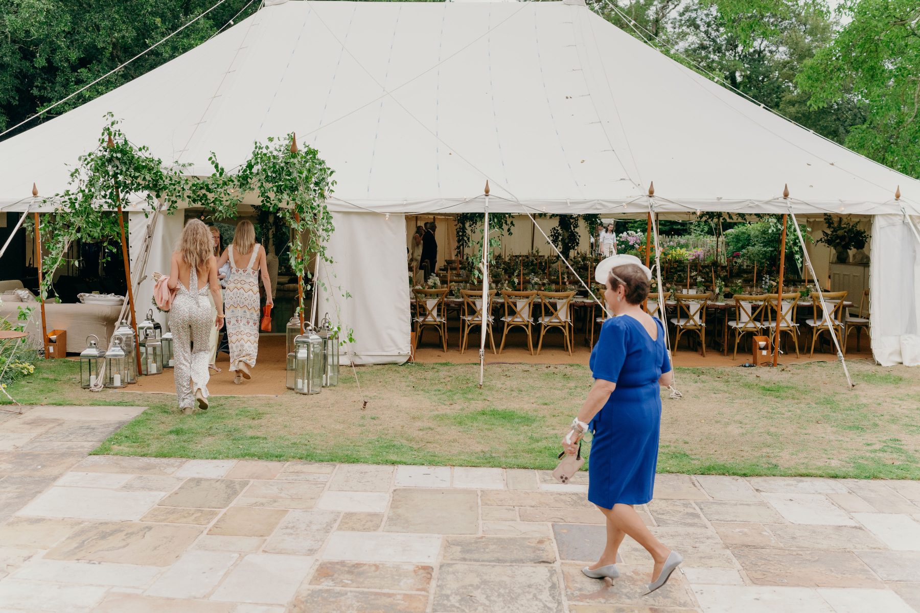 The dinner and dancing cream canvas sailcloth tent up on the house lawn nestled into the garden